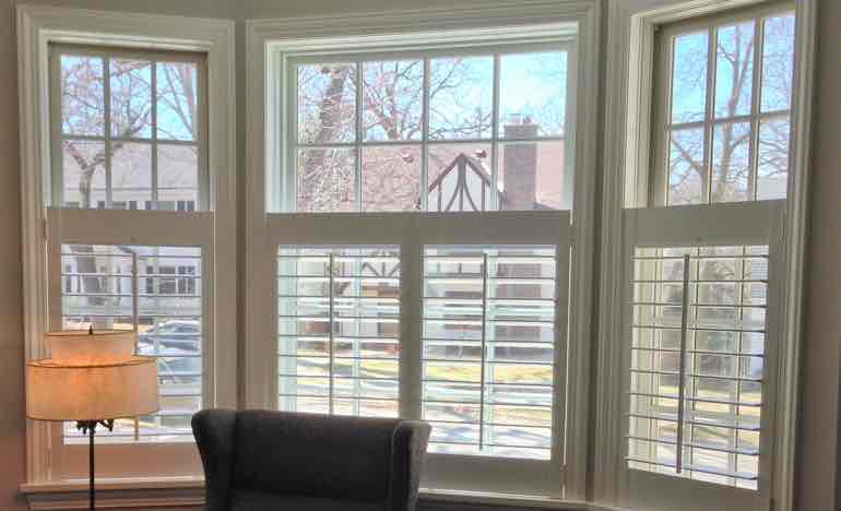 Half plantation shutters in family room bay window.